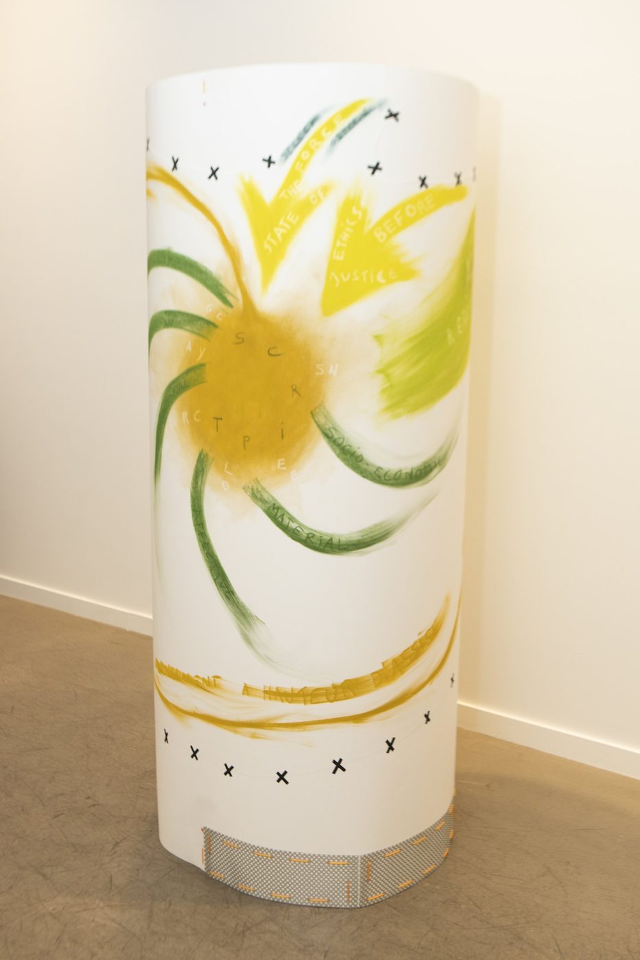 A tall white column painted with yellow and green pastel marks.