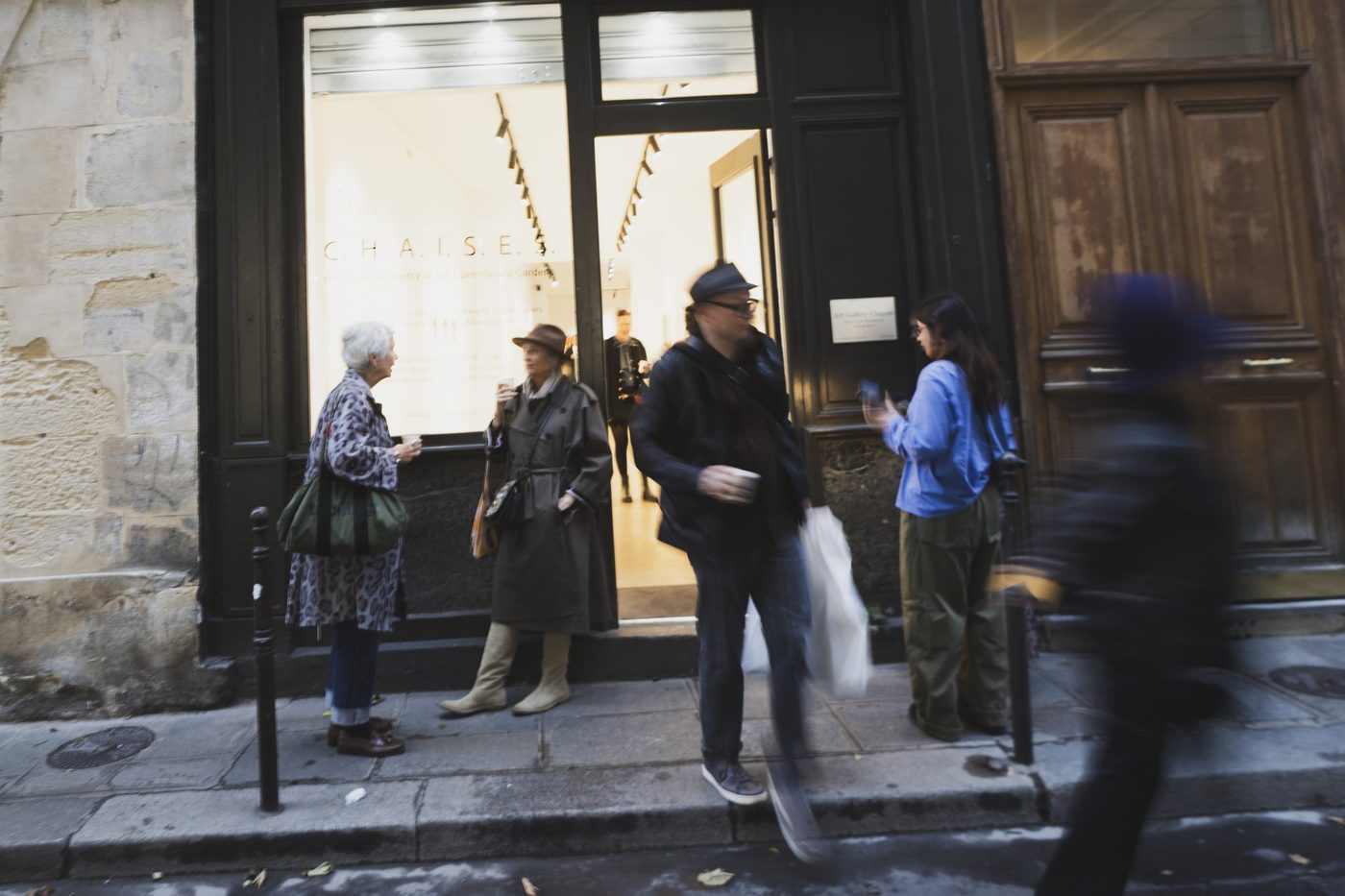 Guests arriving on the pavement outside the gallery.